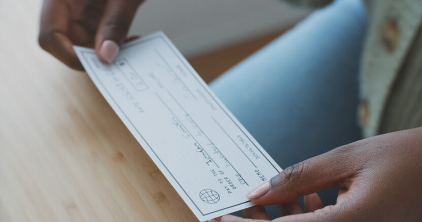 A woman is holding a check in her hands