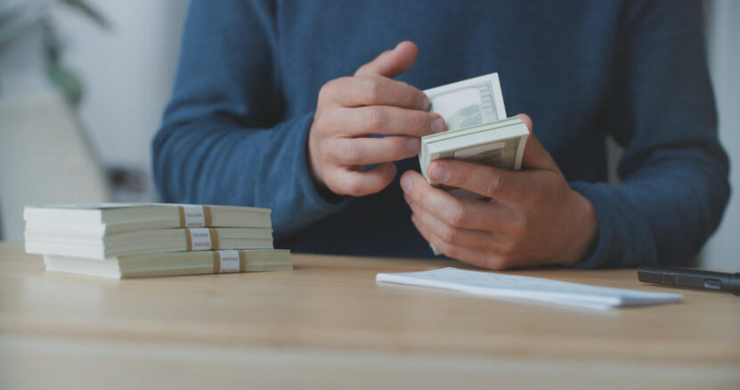 A man is counting money that represents his retained earnings